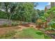 Fenced backyard with a fire pit and established landscaping, offering privacy at 1876 Hamby Place Nw Dr, Acworth, GA 30102