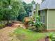A spacious backyard with mature trees, a wooden deck, and a fire pit area at 1876 Hamby Place Nw Dr, Acworth, GA 30102