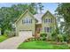 Charming two-story home with green siding, black shutters, attached garage, and manicured landscaping at 1876 Hamby Place Nw Dr, Acworth, GA 30102