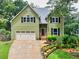 Charming two-story home with green siding, black shutters, attached garage, and landscaped front yard at 1876 Hamby Place Nw Dr, Acworth, GA 30102