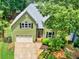 Two-story home with green siding, black shutters, attached garage and walkway with manicured garden at 1876 Hamby Place Nw Dr, Acworth, GA 30102