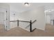 Hallway featuring plush carpet, black and white railing, and multiple doors leading to rooms at 1876 Hamby Place Nw Dr, Acworth, GA 30102