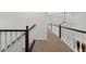 Upstairs hallway featuring plush carpet, black and white railing, and a view of the living room at 1876 Hamby Place Nw Dr, Acworth, GA 30102