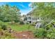 An impressive backyard with a large manicured lawn, lush garden beds and a towering tree canopy at 212 Thorncliff Way Way, Acworth, GA 30101