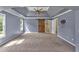 Large bedroom featuring tray ceilings, ceiling fan, neutral carpet, and a barn door to the bathroom at 212 Thorncliff Way Way, Acworth, GA 30101