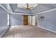 Spacious bedroom featuring tray ceilings, a ceiling fan, a barn door, and neutral carpet at 212 Thorncliff Way Way, Acworth, GA 30101