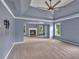 Expansive bedroom showcasing a tray ceiling, modern fan, and an adjacent sitting area with a fireplace at 212 Thorncliff Way Way, Acworth, GA 30101