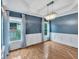 Elegant dining room with hardwood floors, wainscoting, chandelier, and large windows with blue patterned curtains at 212 Thorncliff Way Way, Acworth, GA 30101