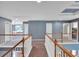 Hallway featuring hardwood railings, neutral colored carpet, and blue-painted walls at 212 Thorncliff Way Way, Acworth, GA 30101