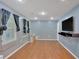 Bright living room with hardwood floors, modern window treatments, and a wall-mounted TV at 212 Thorncliff Way Way, Acworth, GA 30101