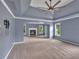 Spacious primary bedroom with tray ceiling, fan, fireplace, and windows offering backyard views at 212 Thorncliff Way Way, Acworth, GA 30101