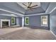 Large primary bedroom with tray ceiling, fan, fireplace, and backyard views from the windows at 212 Thorncliff Way Way, Acworth, GA 30101