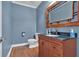 Charming powder room with beautiful wood vanity, granite countertop, and warm-toned wood-framed mirror at 212 Thorncliff Way Way, Acworth, GA 30101