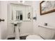 Classic bathroom features a white pedestal sink and toilet, complemented by a framed mirror at 2459 Cedar Canyon Se Ct, Marietta, GA 30067