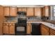 Cozy kitchen features wood cabinets, modern black appliances, and tiled backsplash at 2459 Cedar Canyon Se Ct, Marietta, GA 30067