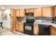 Modern kitchen featuring wood cabinets, black appliances, backsplash, countertops and gray wood flooring at 2459 Cedar Canyon Se Ct, Marietta, GA 30067