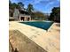 Community pool with a green cover and a pool house surrounded by lush trees on a sunny day at 2459 Cedar Canyon Se Ct, Marietta, GA 30067
