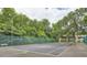 Community tennis court surrounded by a tall fence and mature trees providing shade at 2459 Cedar Canyon Se Ct, Marietta, GA 30067