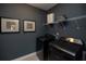 Contemporary laundry room with dark gray walls, modern washer/dryer and wire shelf at 371 Grant Cir # 1812, Atlanta, GA 30315