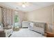 A cute bedroom with a crib, a neutral chair, and a dresser, all under a ceiling fan at 177 Coopers Pond Dr, Lawrenceville, GA 30044