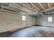 Unfinished basement space with a window and walkout door, featuring an exposed ceiling and concrete floors at 32 Hillcrest Drive Southeast Se Dr, Austell, GA 30168