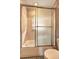 Bathroom showcases a bathtub with sliding glass doors, toilet, and neutral-toned walls and tiling at 32 Hillcrest Drive Southeast Se Dr, Austell, GA 30168