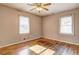 Simple bedroom featuring hardwood floors, two windows with blinds, and a ceiling fan with lighting at 32 Hillcrest Drive Southeast Se Dr, Austell, GA 30168