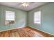 Bedroom features pale-green walls, hardwood floors, two windows with blinds, and a ceiling fan with lighting at 32 Hillcrest Drive Southeast Se Dr, Austell, GA 30168