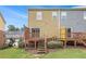 View of the townhome's backyard featuring a wooden deck and staircase descending to a well-maintained grassy area at 801 Tulip Poplar Way # 2501, Lawrenceville, GA 30044