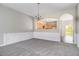 Formal dining room with chandelier and wainscoting; view of kitchen through an archway at 801 Tulip Poplar Way # 2501, Lawrenceville, GA 30044