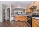 Open kitchen with stainless steel appliances, light wood cabinets, tile backsplash, and dark wood-look floors at 801 Tulip Poplar Way # 2501, Lawrenceville, GA 30044