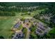 Aerial view of community golf course with clubhouse, manicured greens, and trees at 805 River Valley Dr, Dacula, GA 30019