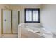 Bathroom features a glass shower stall and a soaking tub with a window at 805 River Valley Dr, Dacula, GA 30019