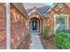 Close-up view of a stylish brick home entrance with an elegant front door and manicured landscape at 805 River Valley Dr, Dacula, GA 30019