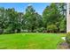 Lush green backyard with mature trees and landscaping, offering a private and serene outdoor space at 106 April Walk, Mcdonough, GA 30253