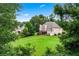 Expansive backyard with lush green lawn, mature trees, and a wooden deck, perfect for outdoor entertaining and relaxation at 106 April Walk, Mcdonough, GA 30253