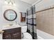 Bathroom with a dark wood vanity, patterned shower curtain, and bright lighting at 106 April Walk, Mcdonough, GA 30253