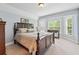 Bedroom with a wooden bedframe, bay windows, and neutral carpet at 106 April Walk, Mcdonough, GA 30253