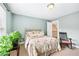 Cozy bedroom with a floral patterned bed, rocker chair, and bright green plant at 106 April Walk, Mcdonough, GA 30253