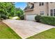 Long, paved driveway leads to an attached garage, complemented by lush landscaping and mature trees, providing excellent curb appeal at 106 April Walk, Mcdonough, GA 30253