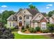 Charming stone and stucco home featuring mature landscaping and a well-manicured lawn at 106 April Walk, Mcdonough, GA 30253