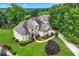 Aerial view of a stately home with manicured landscaping, a circular driveway, and lush greenery, nestled in a serene setting at 106 April Walk, Mcdonough, GA 30253