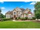 Charming front exterior with stone accents, arched windows, manicured bushes, and a lush green lawn at 106 April Walk, Mcdonough, GA 30253
