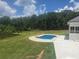 Expansive backyard with a sparkling pool and views of a serene pond and lush greenery at 1169 Hodges Cir, Mansfield, GA 30055