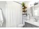 Clean bathroom with grey vanity, white shower curtain, decorative shelves and modern lighting at 1169 Hodges Cir, Mansfield, GA 30055