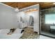 Bright bathroom with a glass shower, double vanities, stone floors, wood ceiling and modern lighting at 1169 Hodges Cir, Mansfield, GA 30055