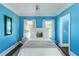 Stylish bedroom with a large bed, blue walls, two windows, and a modern ceiling light at 1169 Hodges Cir, Mansfield, GA 30055