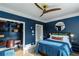 Comfortable bedroom with stylish blue walls and a built-in desk and shelving at 1169 Hodges Cir, Mansfield, GA 30055