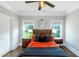 Cozy bedroom featuring a wood-framed bed, two windows, hardwood floors, and modern decor at 1169 Hodges Cir, Mansfield, GA 30055