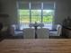 Dining area with hardwood floors and large windows overlooking the landscaped yard adjacent to the kitchen at 1169 Hodges Cir, Mansfield, GA 30055